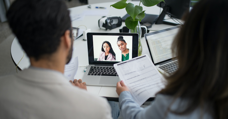 two people interviewing two other people through a computer for a job