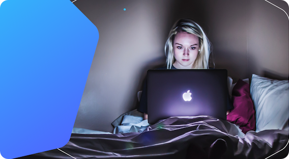 Picture of young woman using a laptop in a dark room.