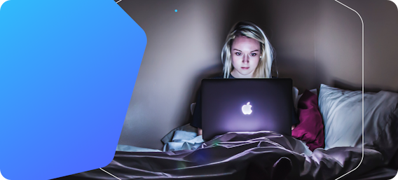 Picture of young woman using a laptop in a dark room.