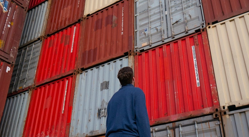 Person looking up at shipping containers