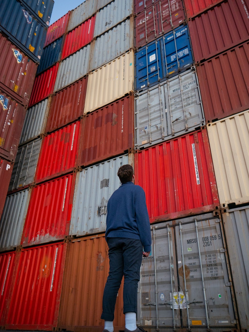 Person looking up at shipping containers