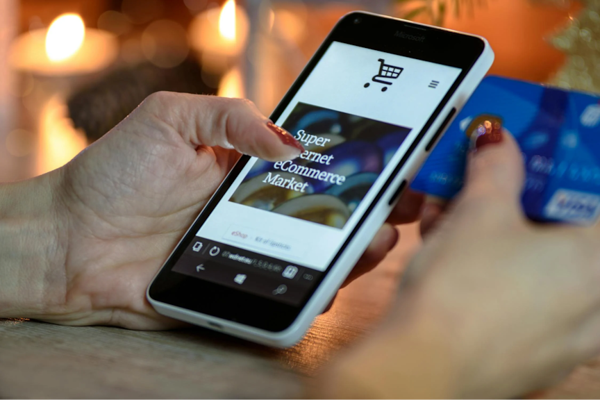 Close up photo of woman holding a smartphone and credit card