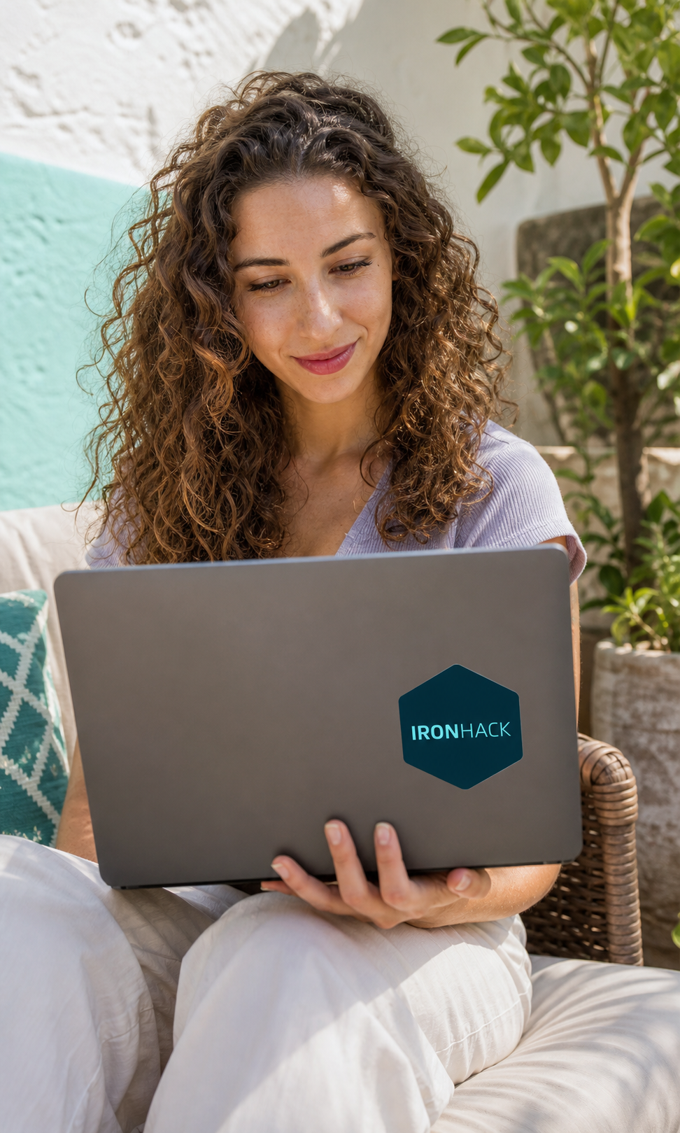 Alumna aprendiendo con un portátil con pegatina de Ironhack