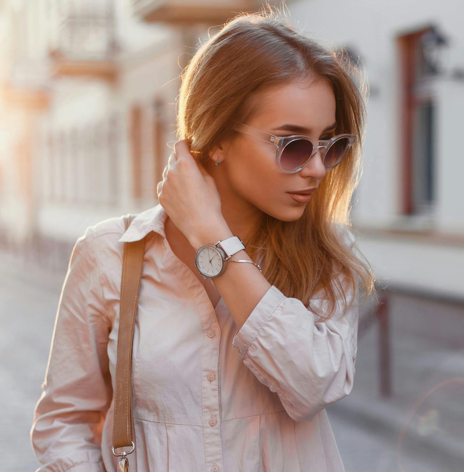 woman with sunglasses moving her hair out the way
