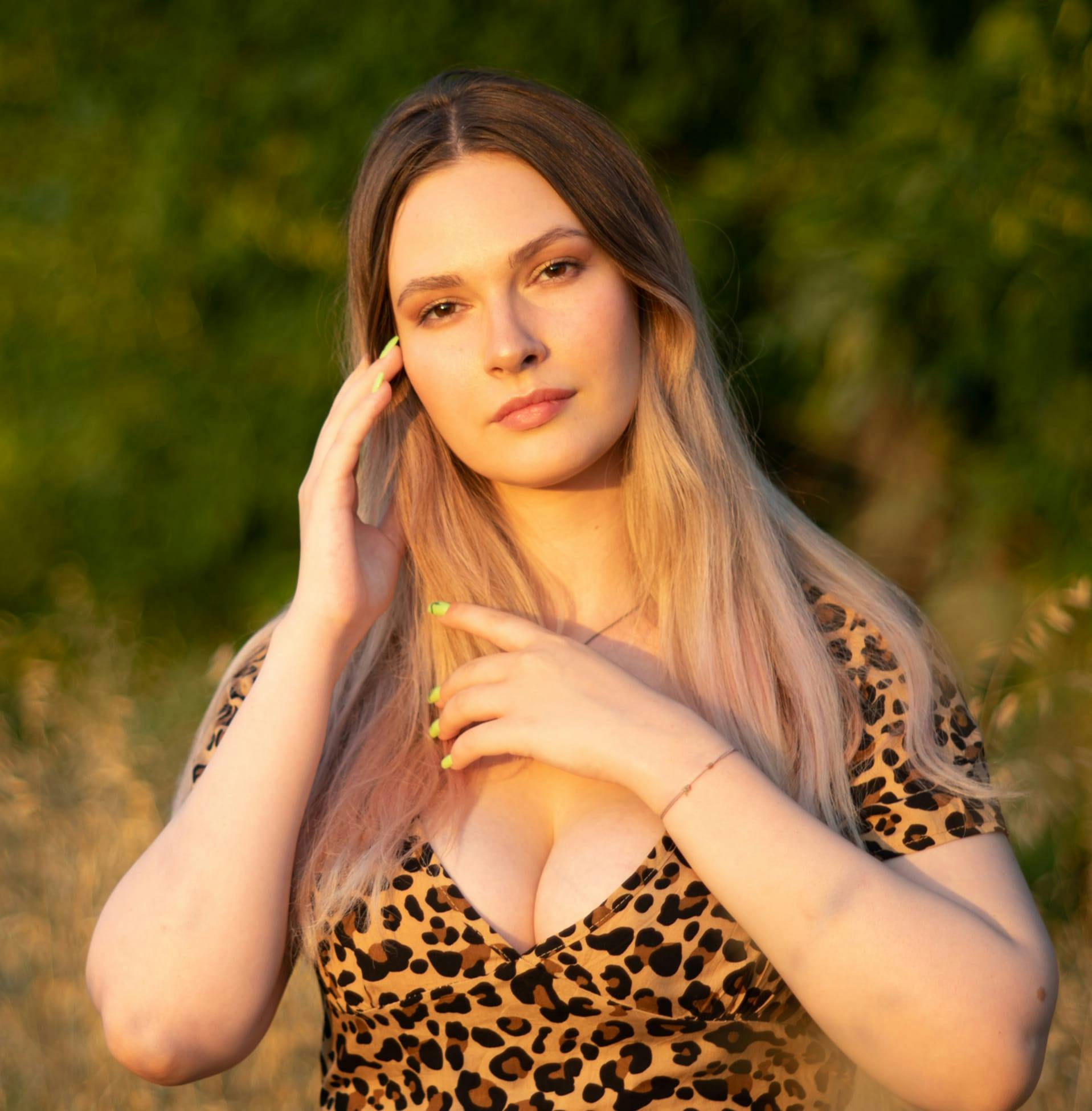 woman in cheetah print top with hand near her neck
