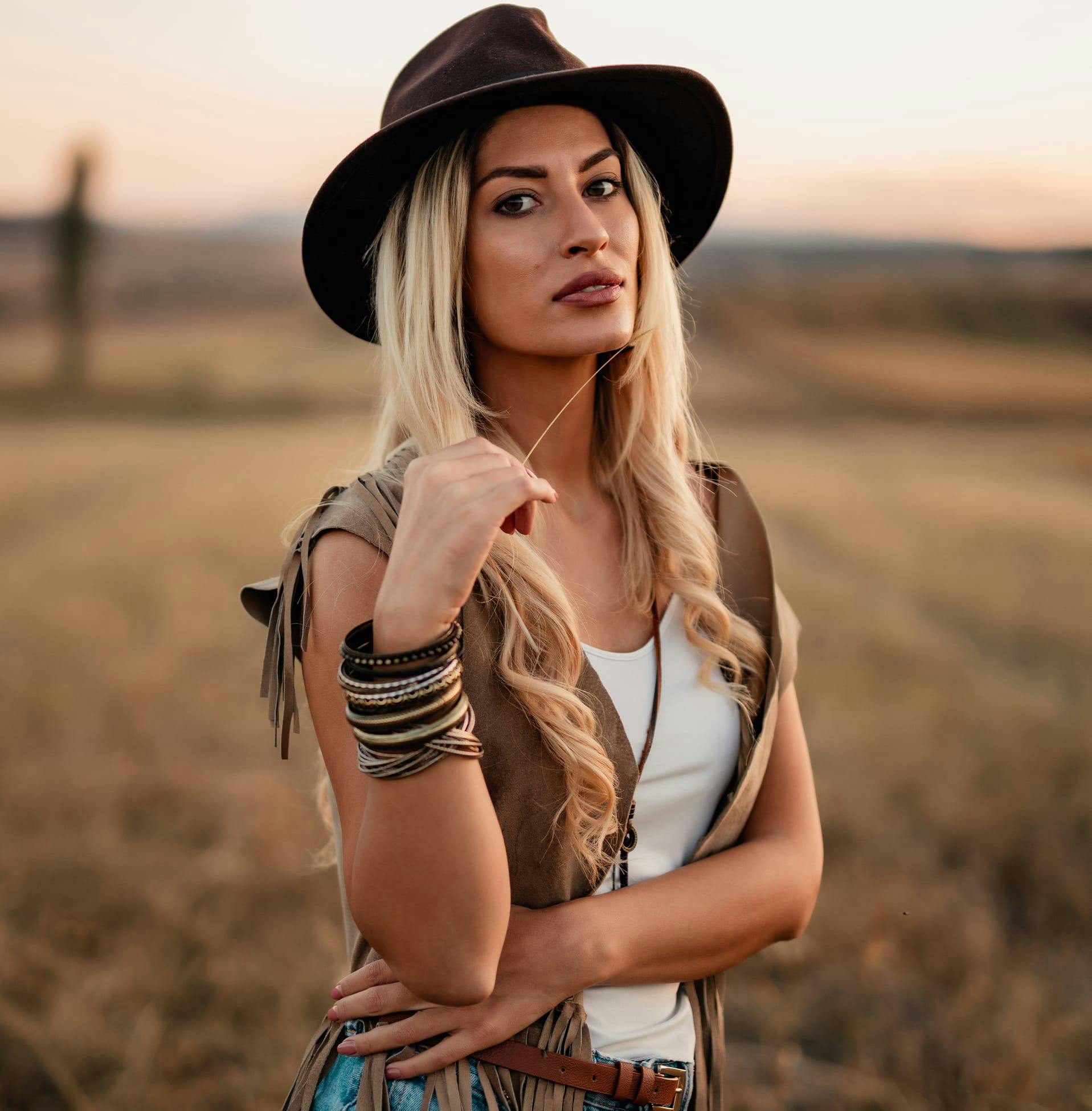 woman wearing brimmed hat with leather vest