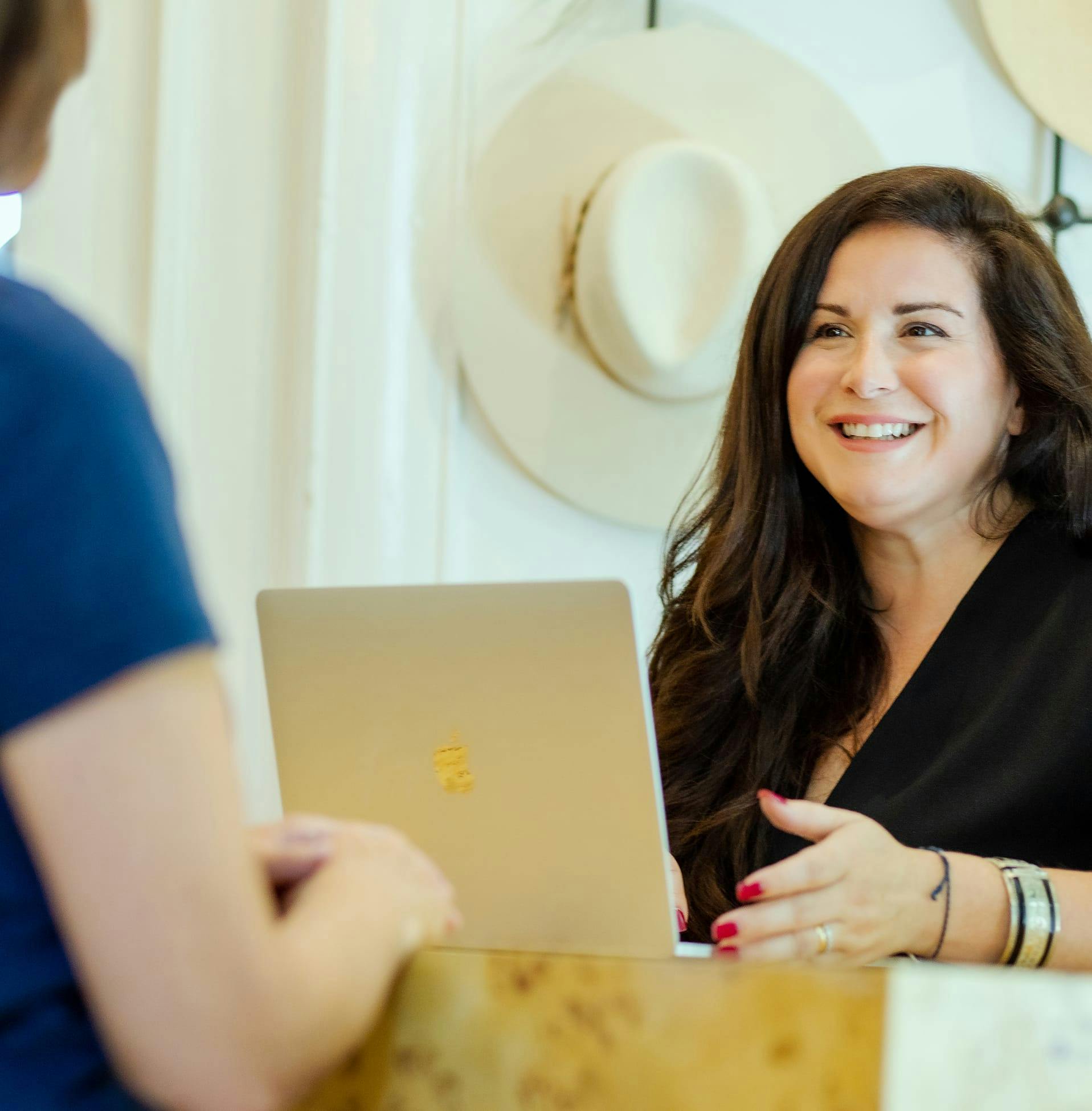 woman smiling with laptop in front of her