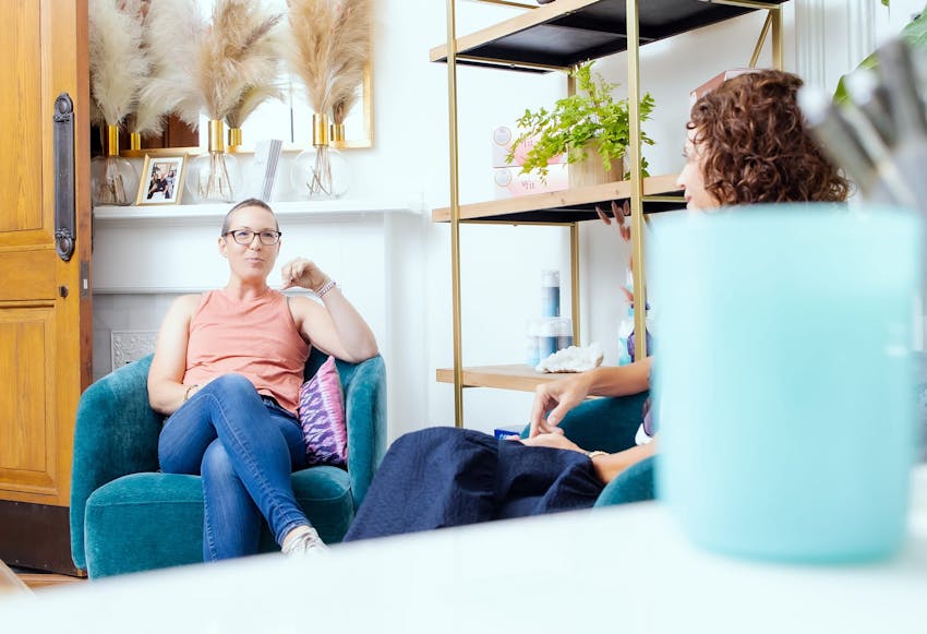 women speaking to eachother while sitting on a seat and couch