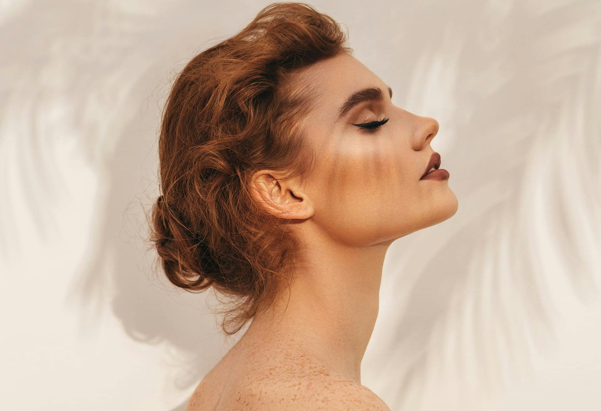 side profile of woman tilting her head upward