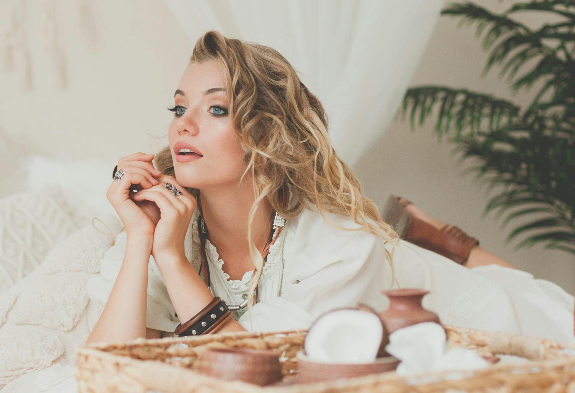 woman laying on bed with tray in front of her