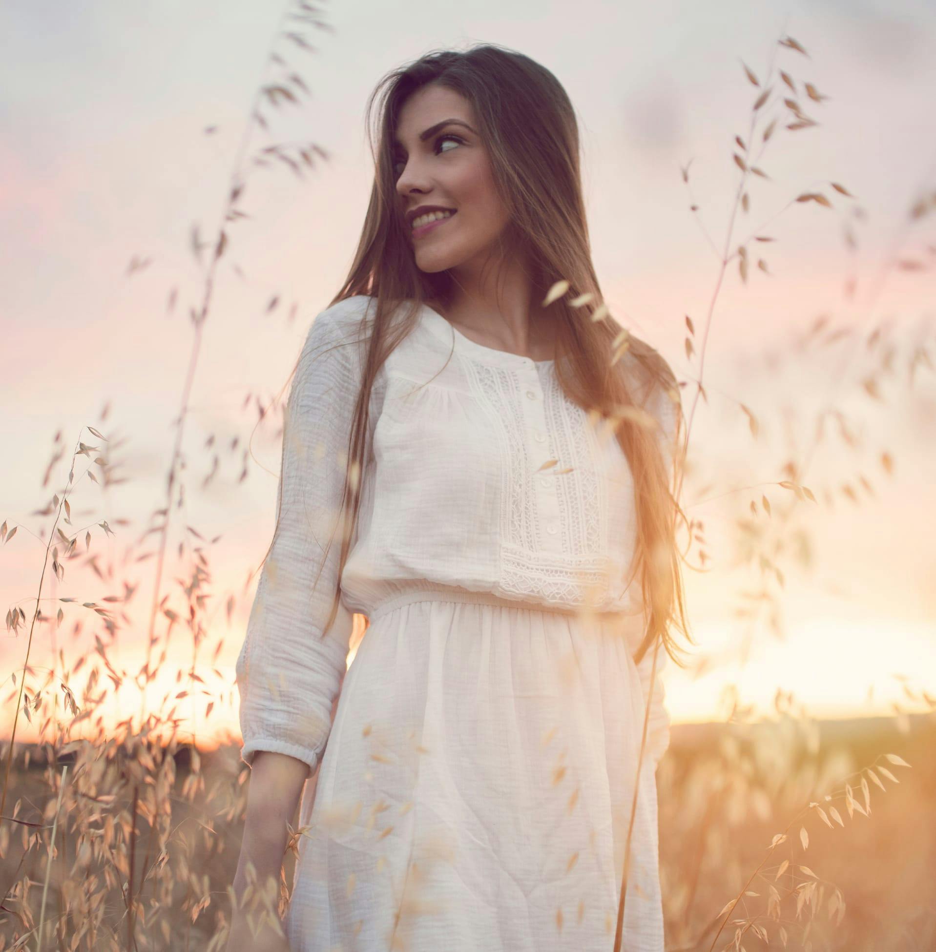 woman in field smiling while looking to the left