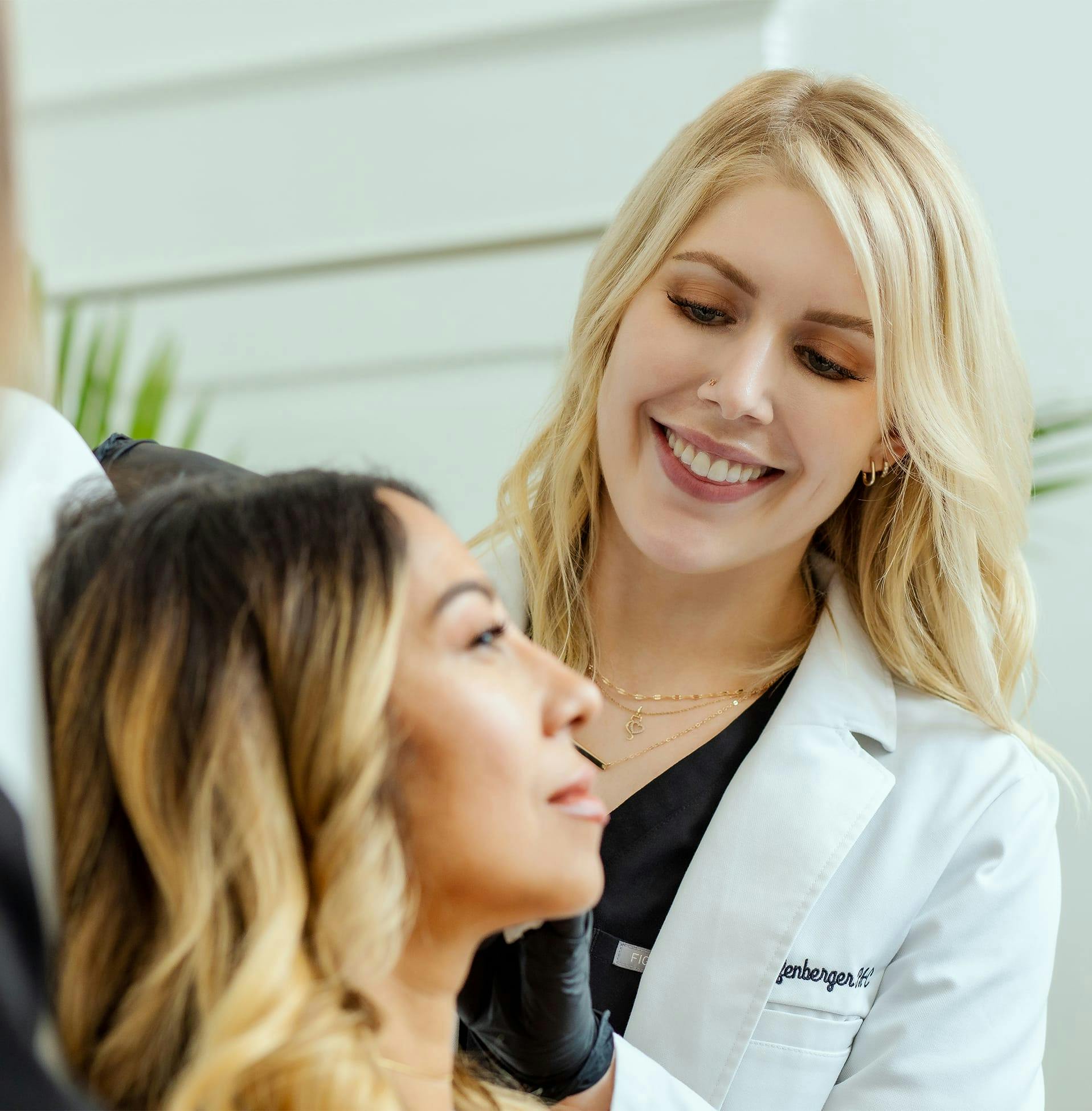 woman smiling at another woman who's sitting in exam chair