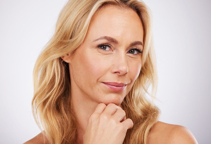 blonde woman with hand under her chin