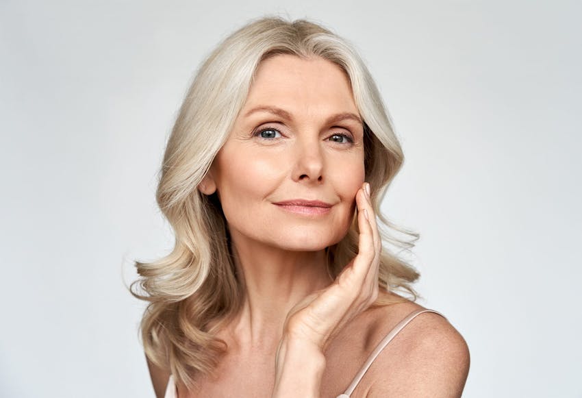 older woman touching her cheek