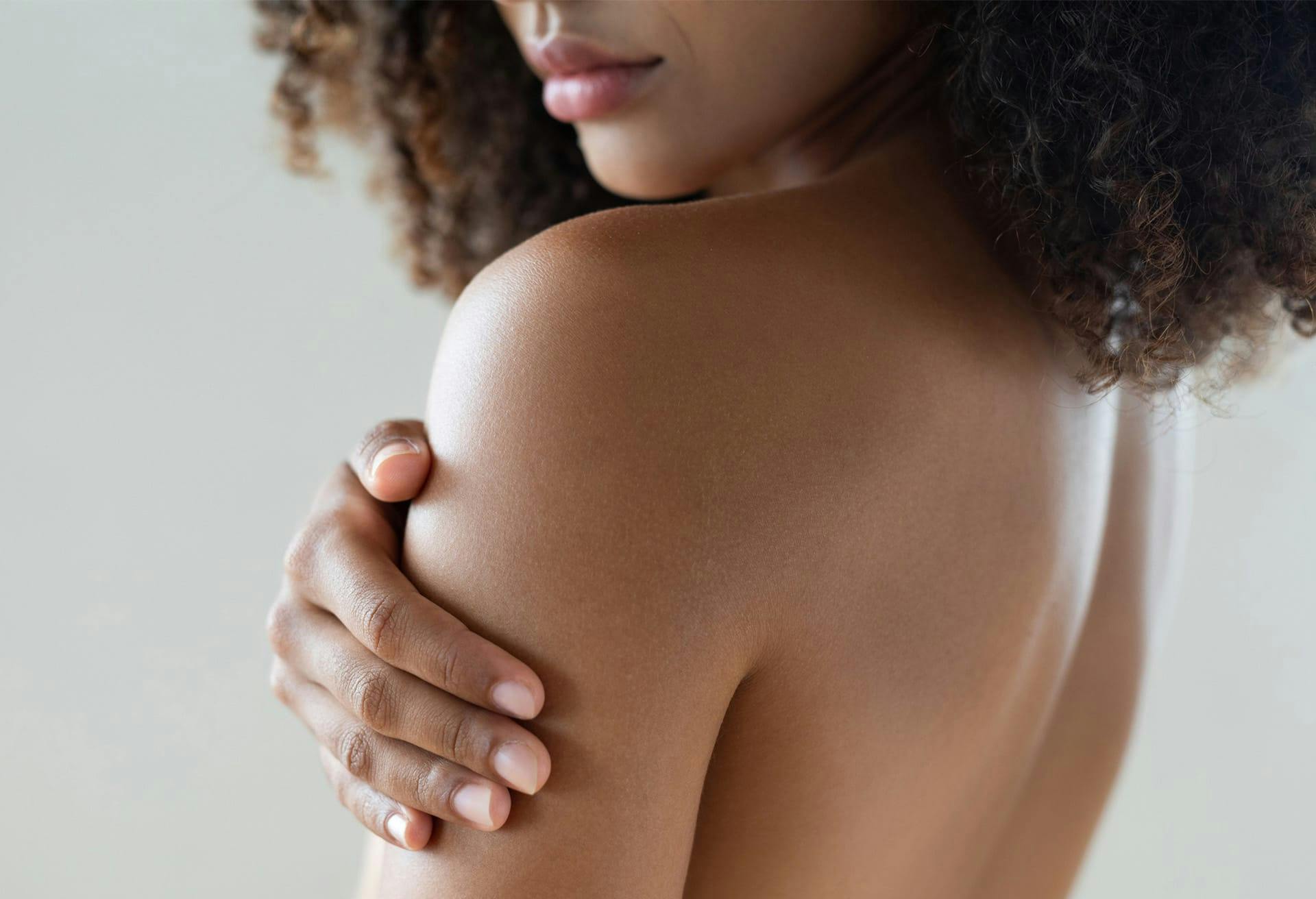 woman holding her shoulder