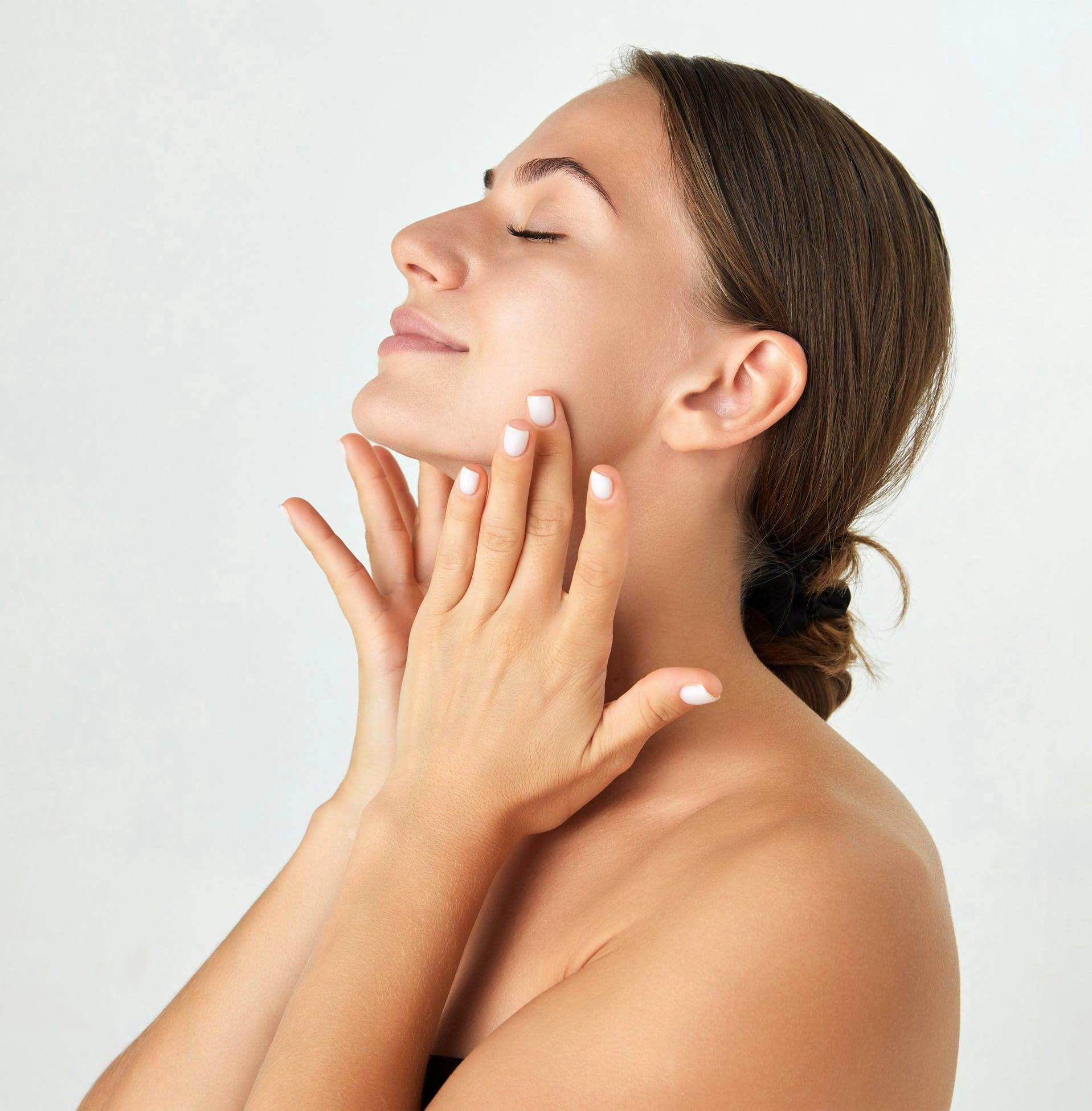 woman leaning her head back and touching her jaw