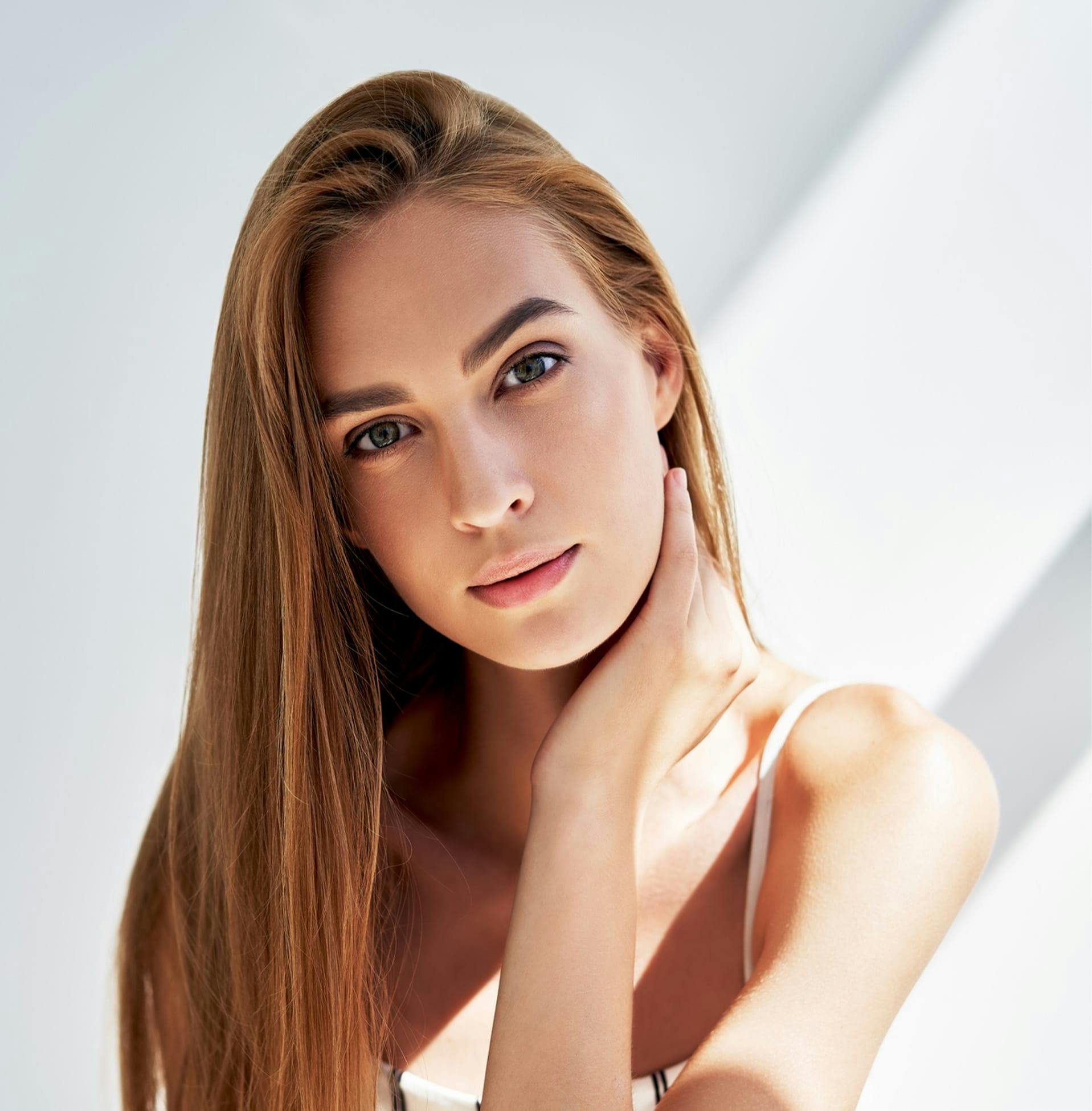 woman with her hand on the side of her neck