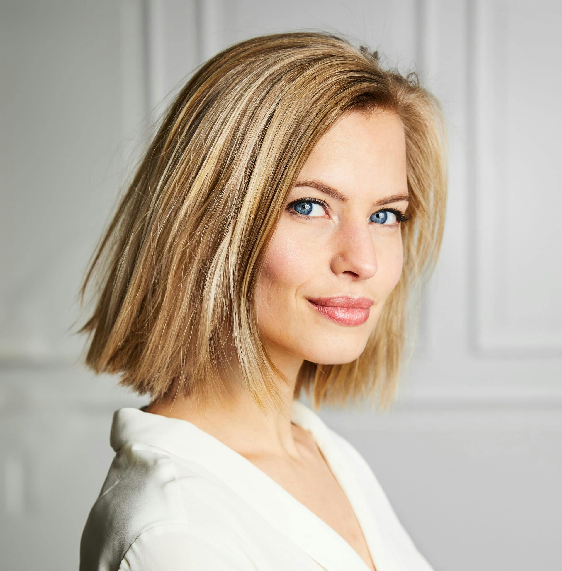 woman with short blonde hair in white top