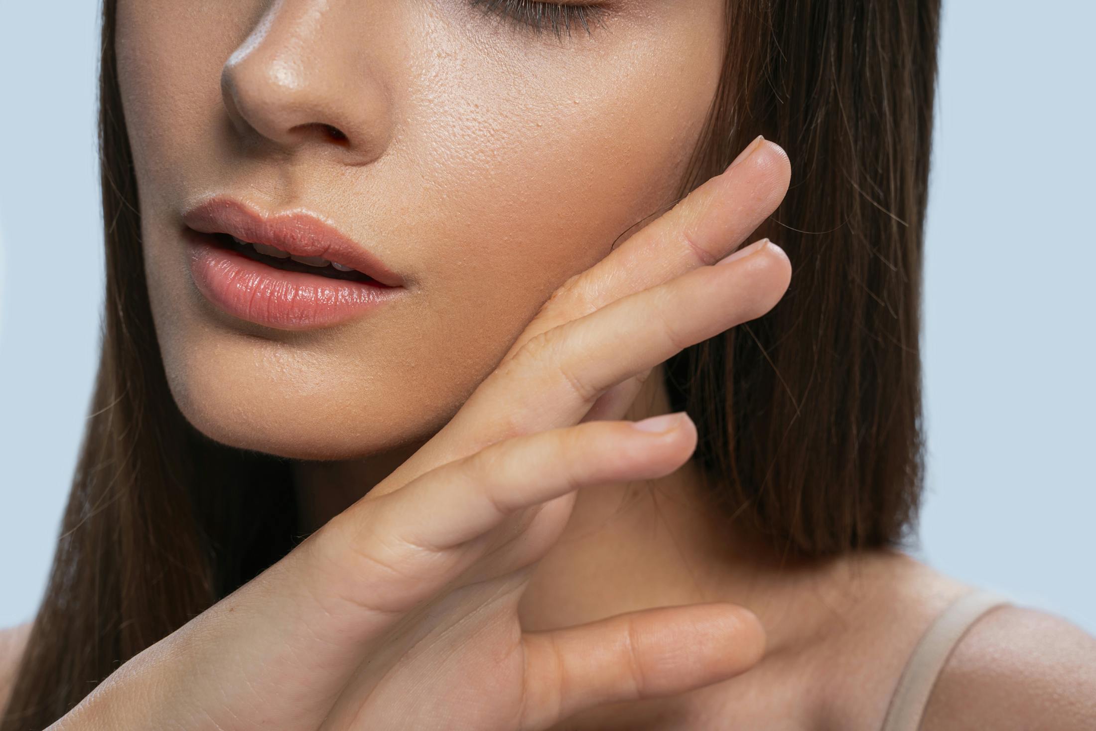 woman brushing her cheek with the back of her hand