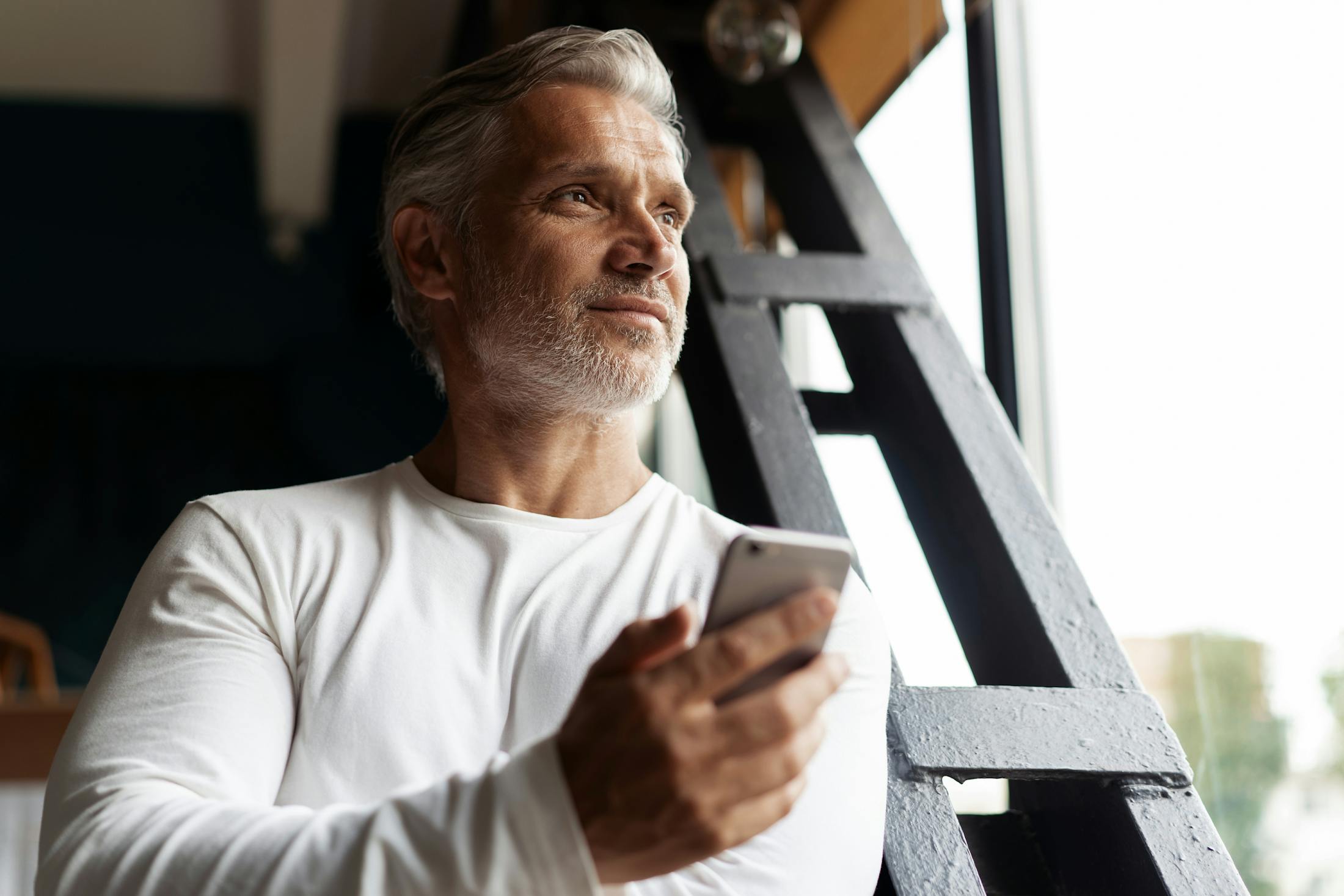 middle aged man holding his cell phone