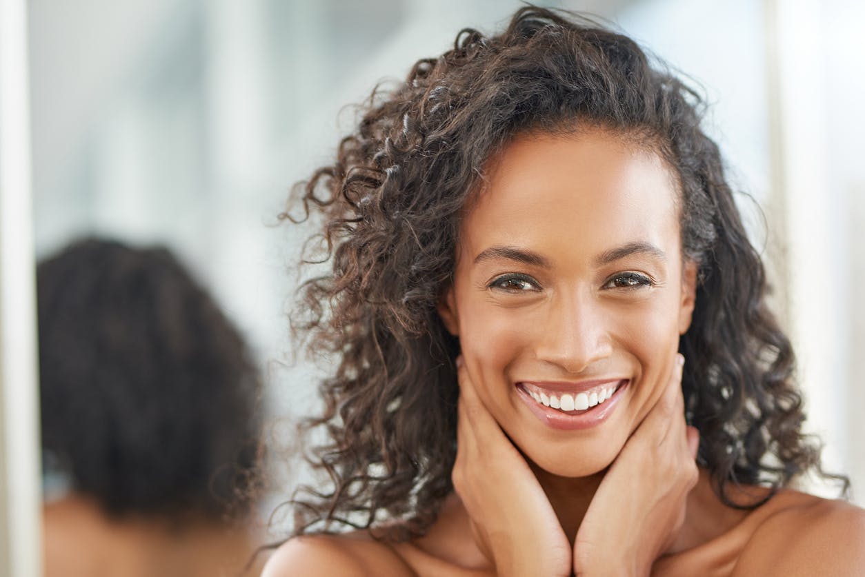 model resting her hands on her collarbone