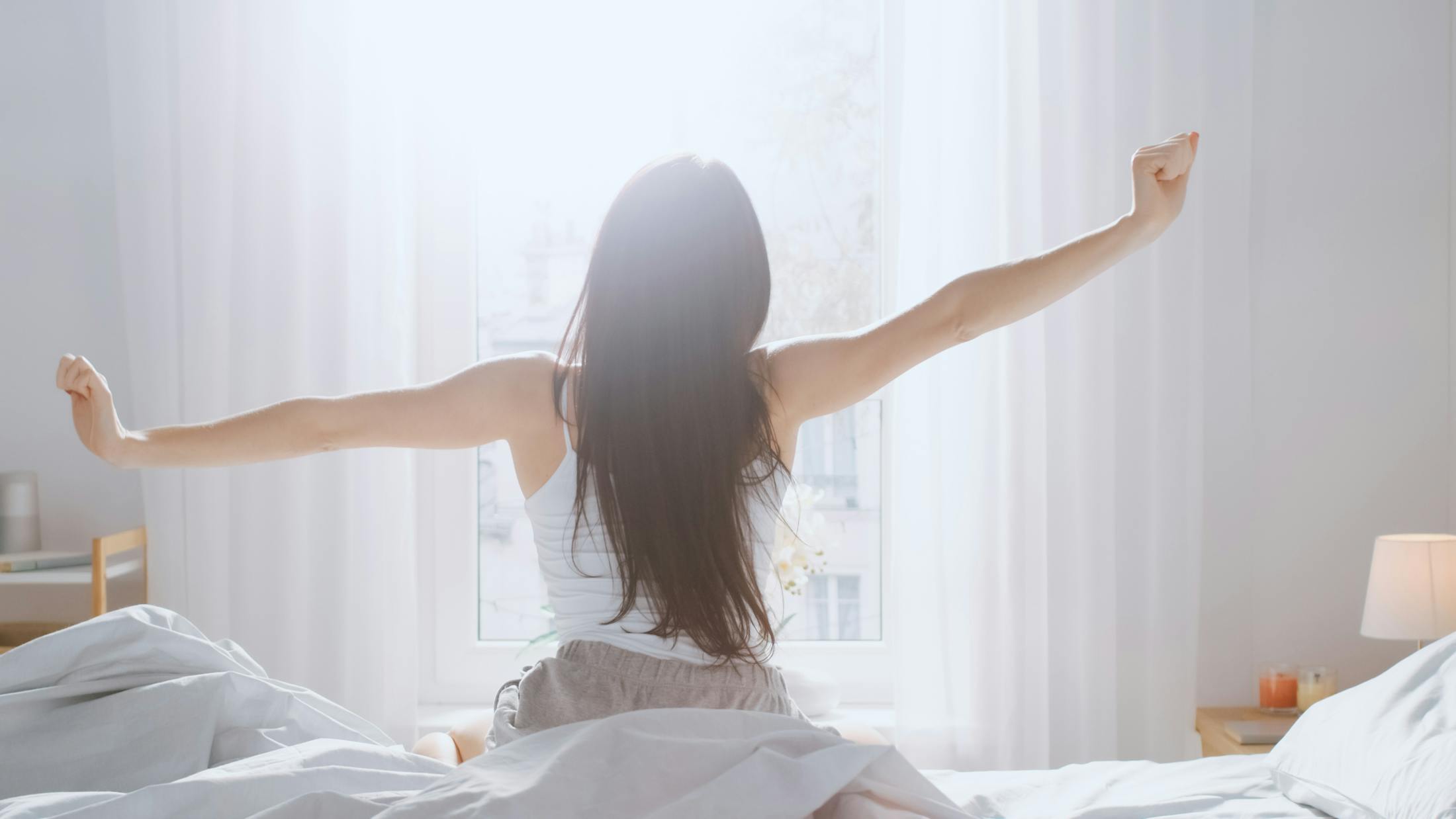 woman stretching in bed