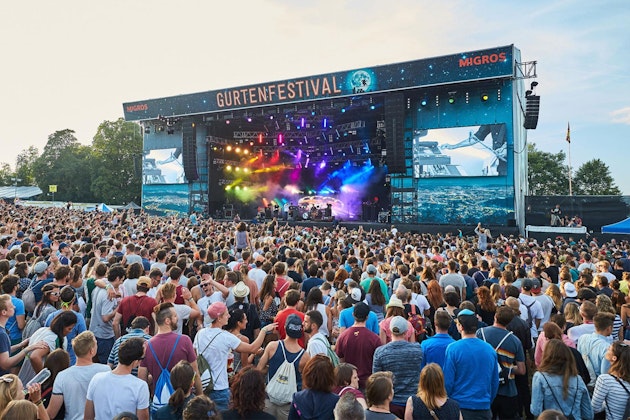 Palco principale del Gurtenfestival gremito di pubblico con illuminazione colorata e schermi LED laterali