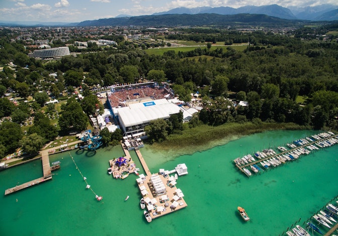 Vue aérienne du Klagenfurt Beach Volleyball Major, avec une arène comble au bord du lac Wörthersee