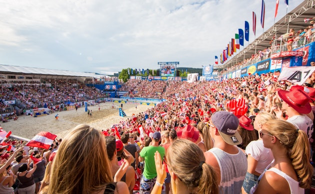 La tribune NÜSSLI, pleine à craquer, lors du Klagenfurt Beach Volleyball Major, avec des supporters en liesse