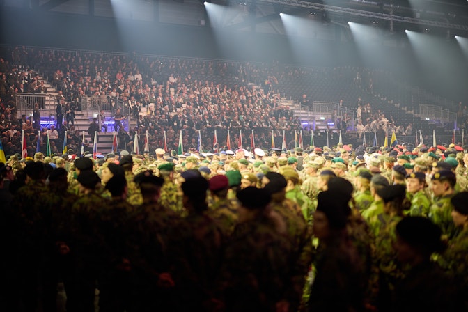 Cerimonia di apertura dei 5° Giochi mondiali militari invernali a Lucerna, con i soldati schierati e le bandiere nazionali davanti a una tribuna gremita
