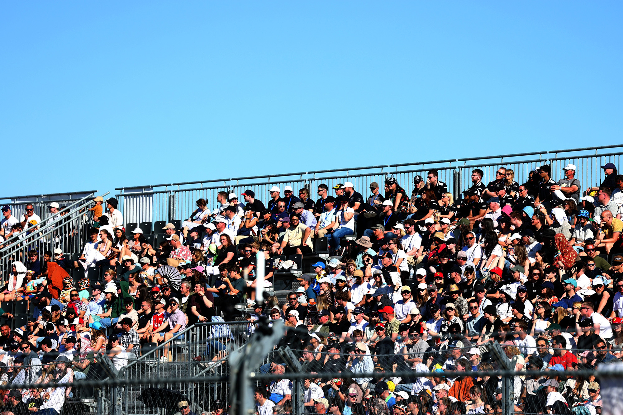Vollbesetzte NÜSSLI-Tribüne beim Berlin E-Prix 2026 unter strahlend blauem Himmel.