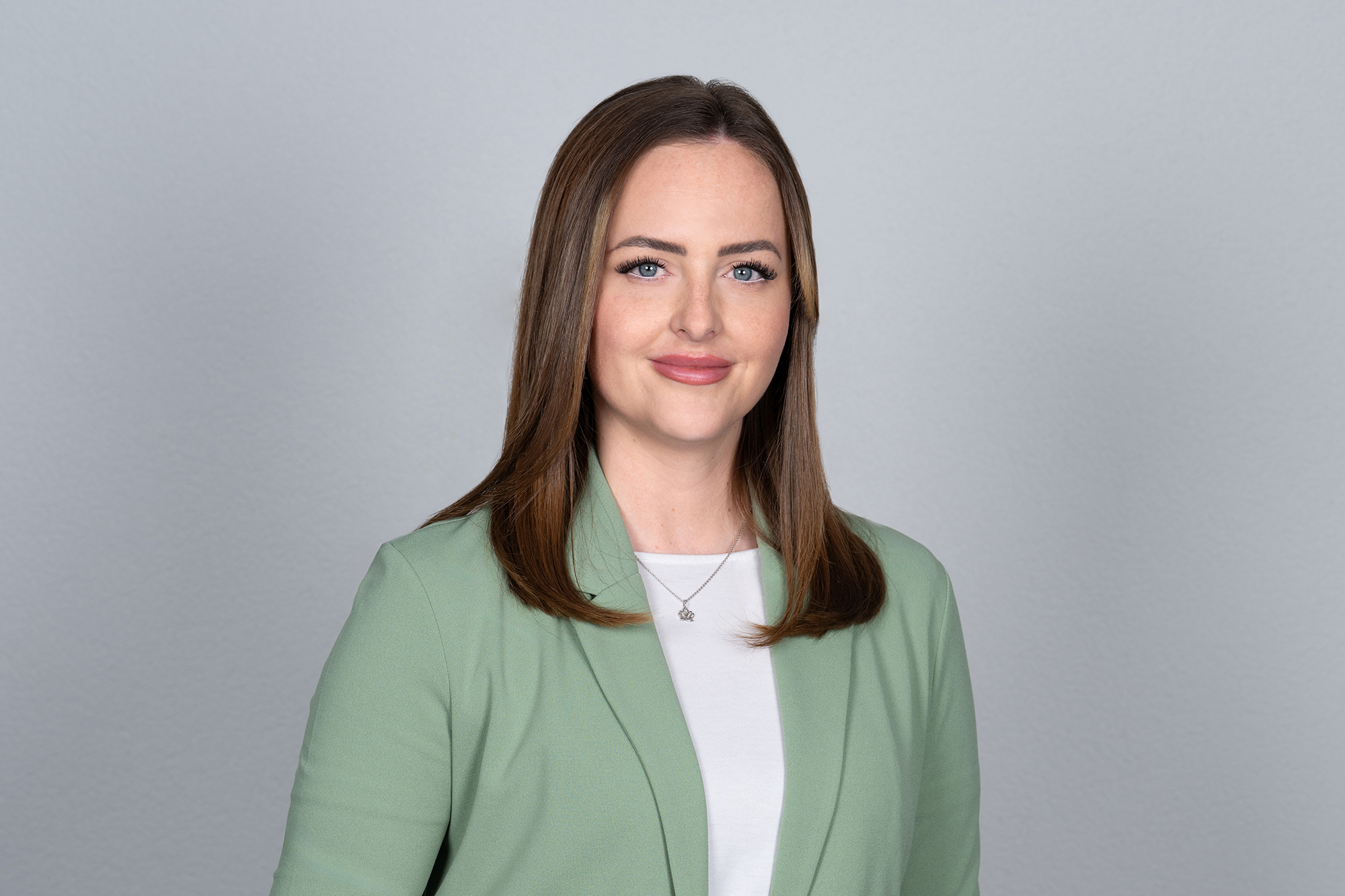 Porträt von Corina Frei, Mitarbeiterin bei NÜSSLI, im grünen Blazer