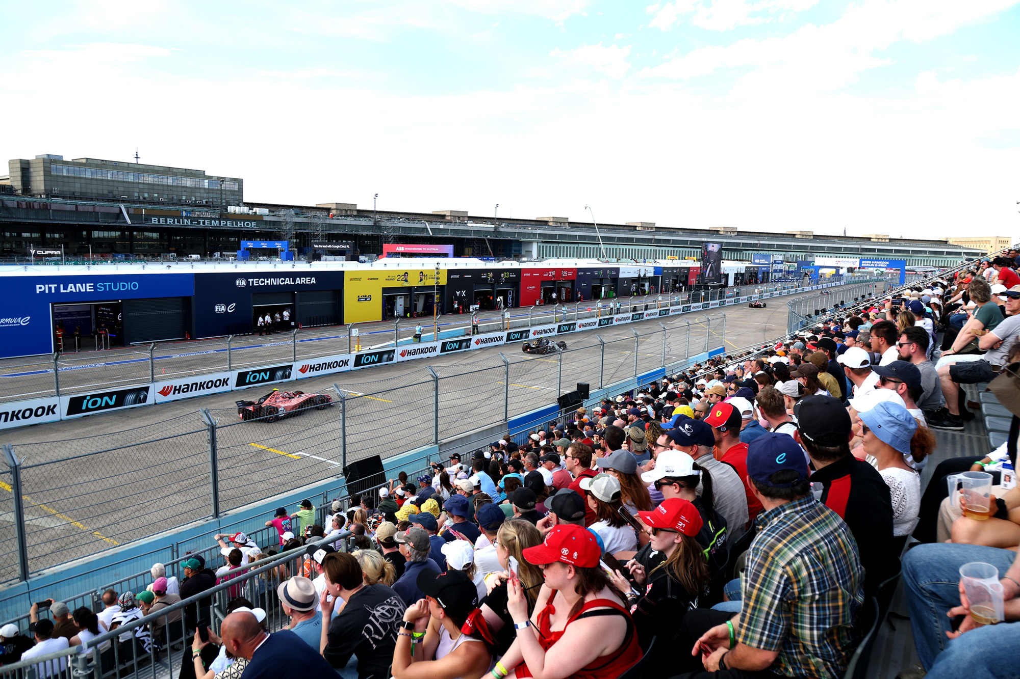 NÜSSLI-Tribüne am Berlin E-Prix, vollbesetzt mit Zuschauern neben der Start-Ziel-Geraden am Flughafen Tempelhof.
