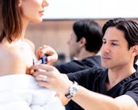 Dr. Cohen measuring top of patient's breast. 