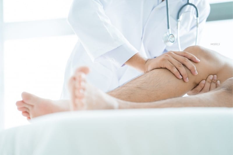Clinician attending to patient's knee.
