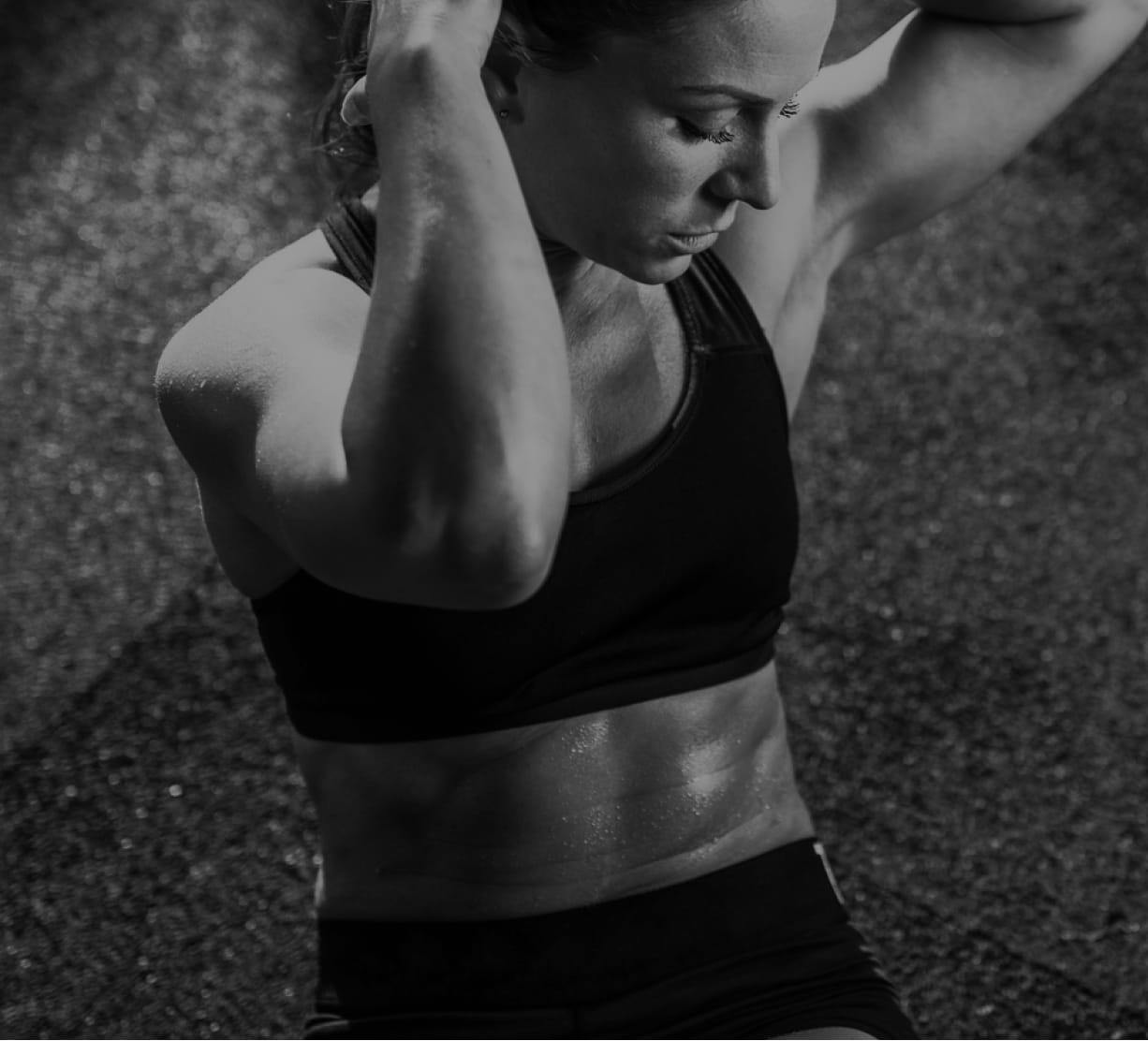 woman in workout clothes, tying up her hair