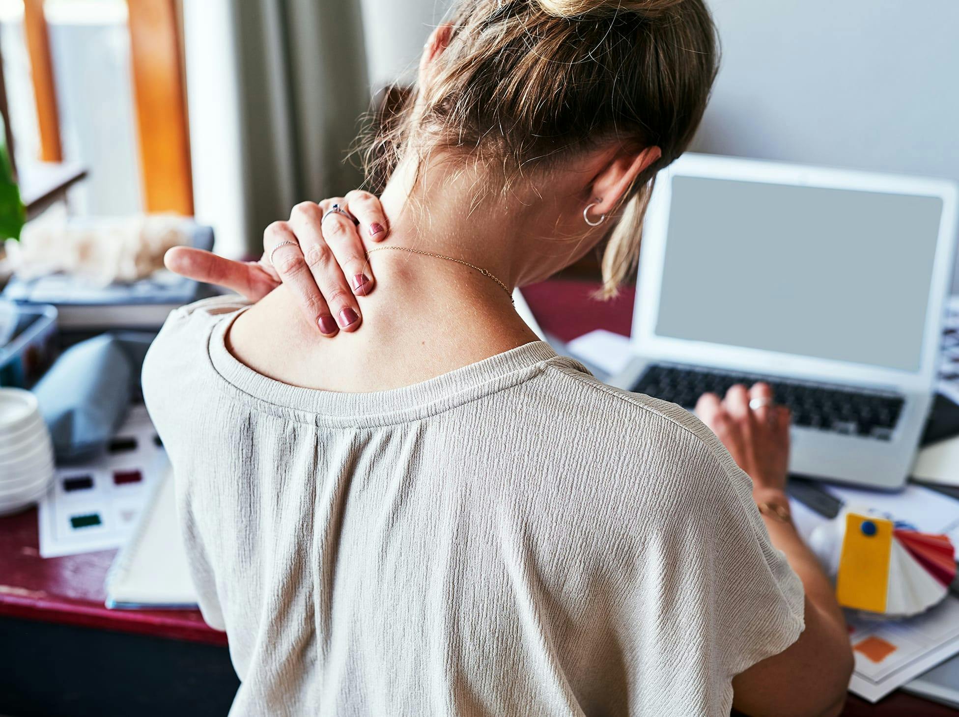 woman holding the back of her neck