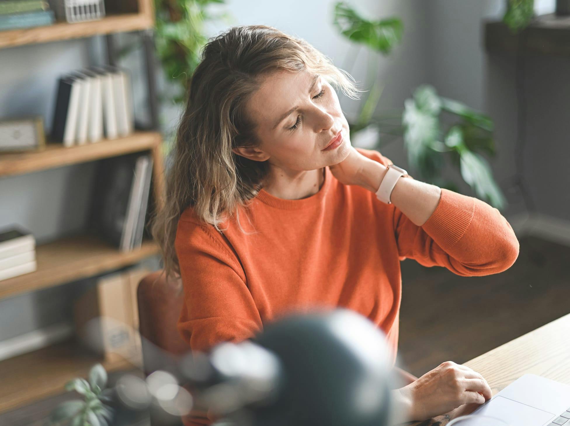 woman rubbing her neck in pain