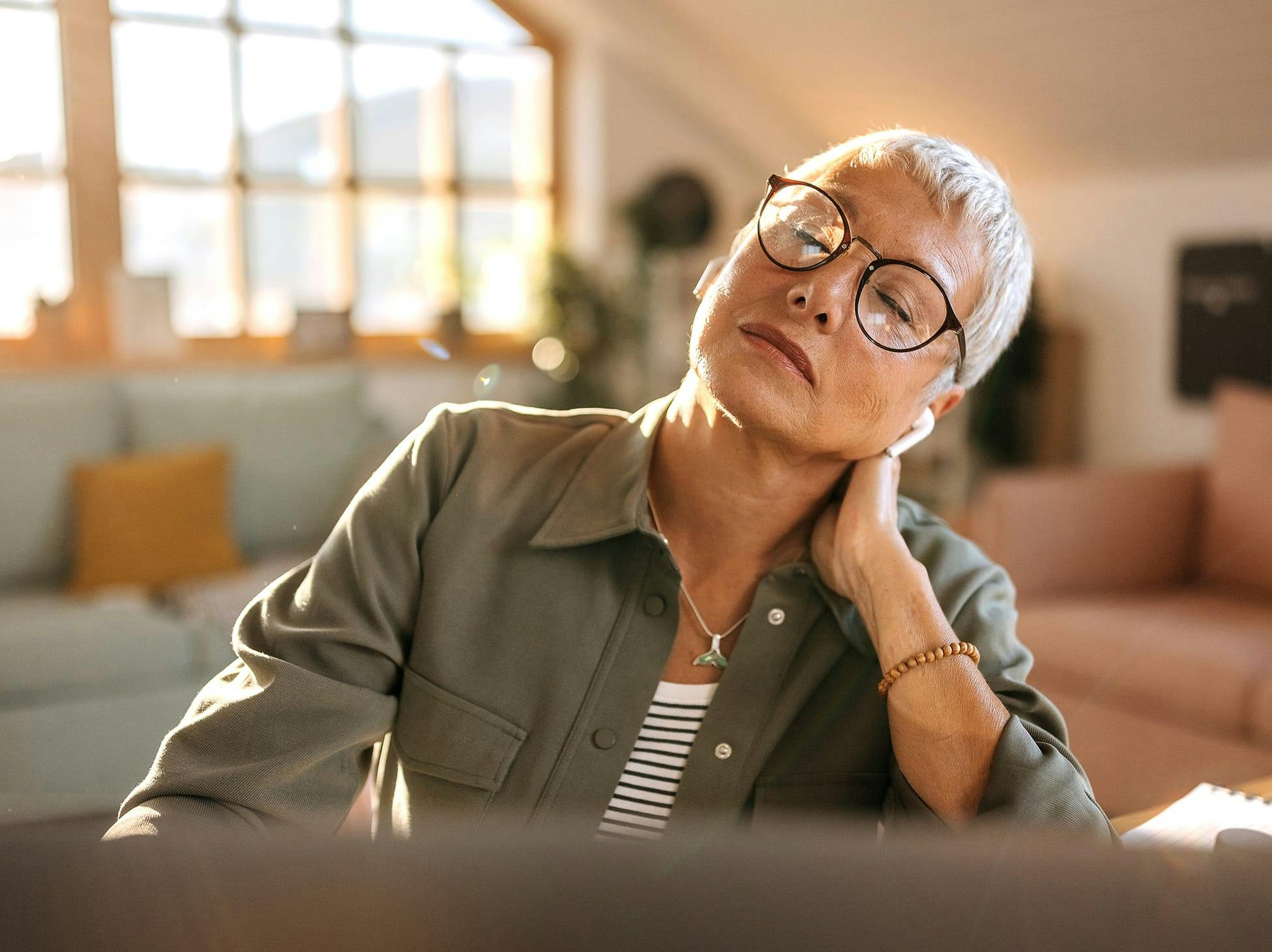woman rubbing her neck in pain
