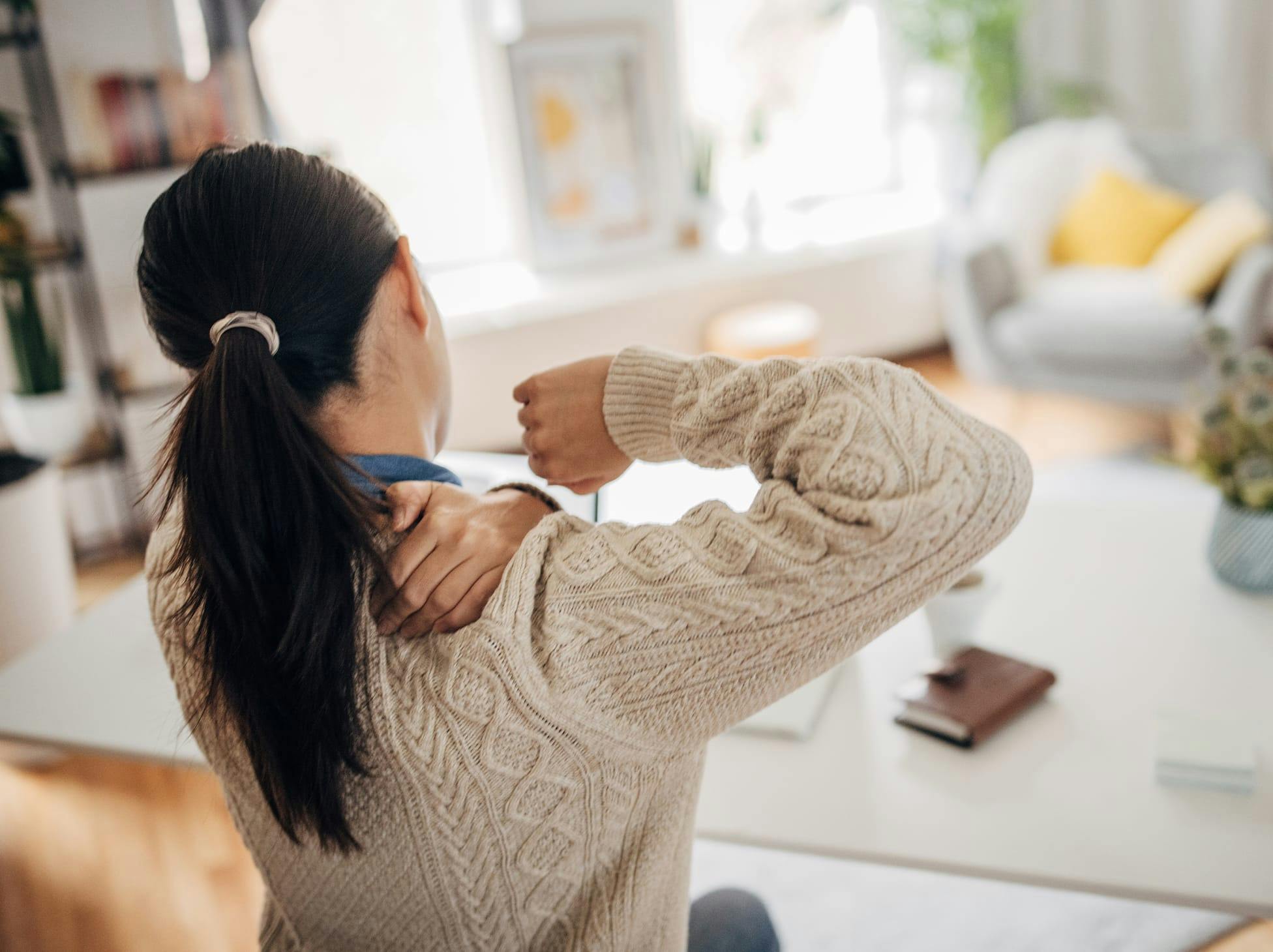 woman holding her shoulder