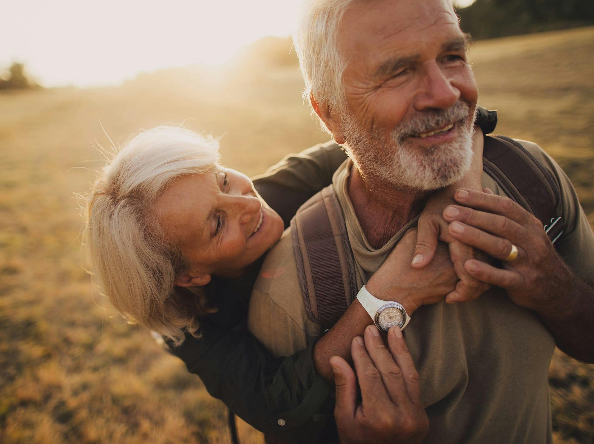 older woman hugging older man from behind