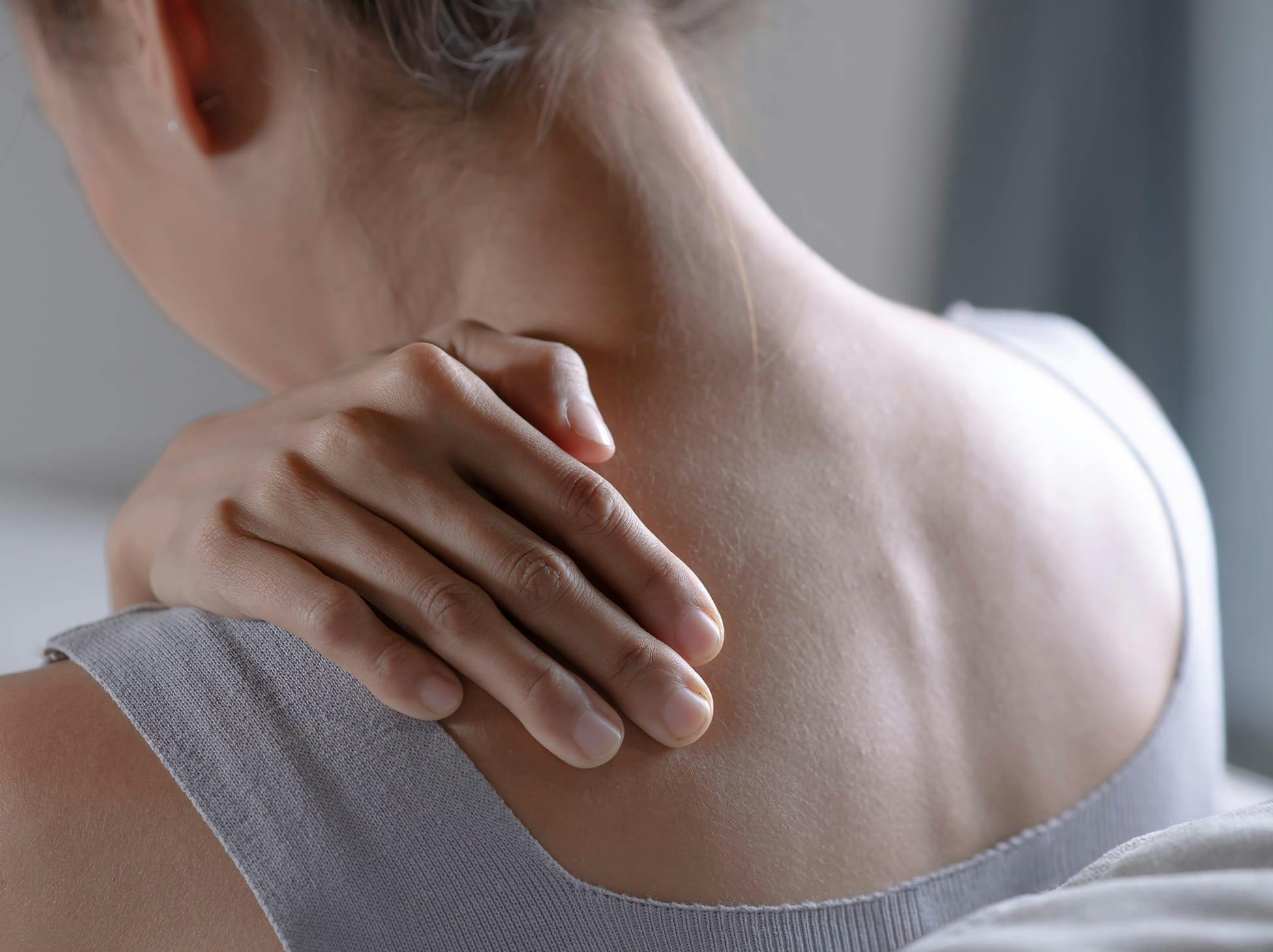 woman holding her shoulder