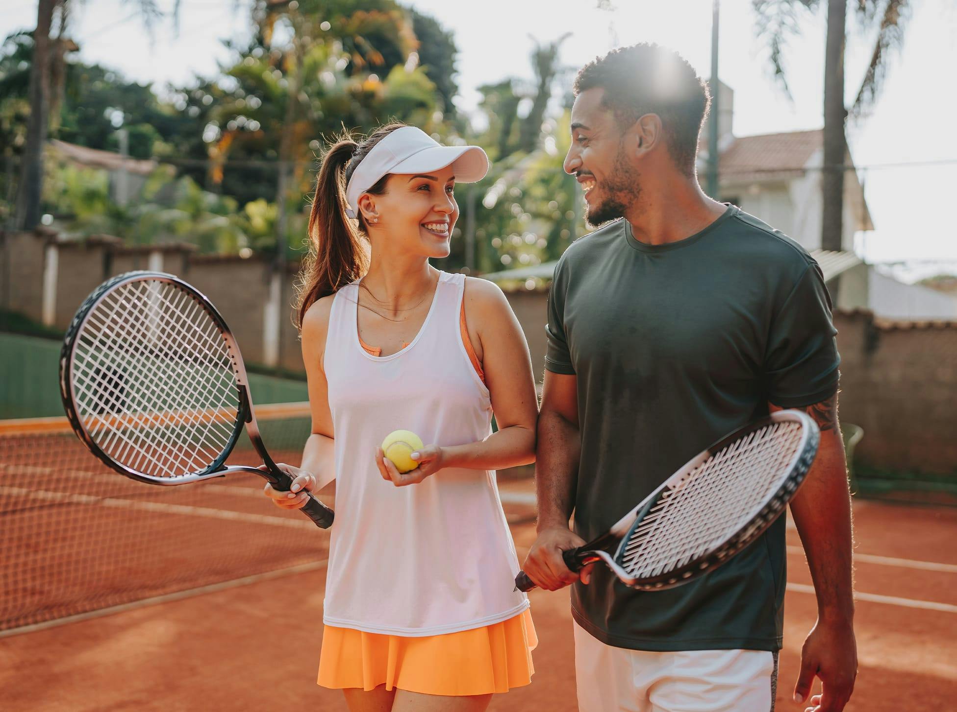 man and woman holding tennis rackets