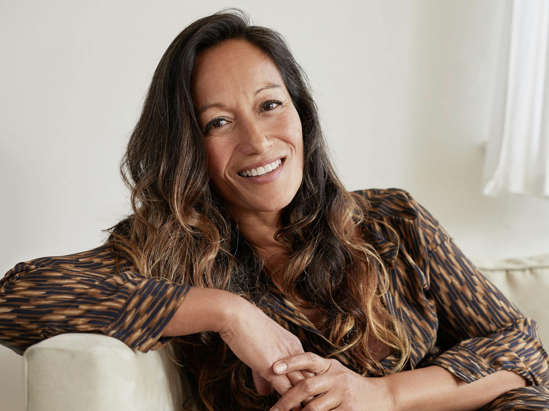 woman sitting on a couch, leaning against the arm