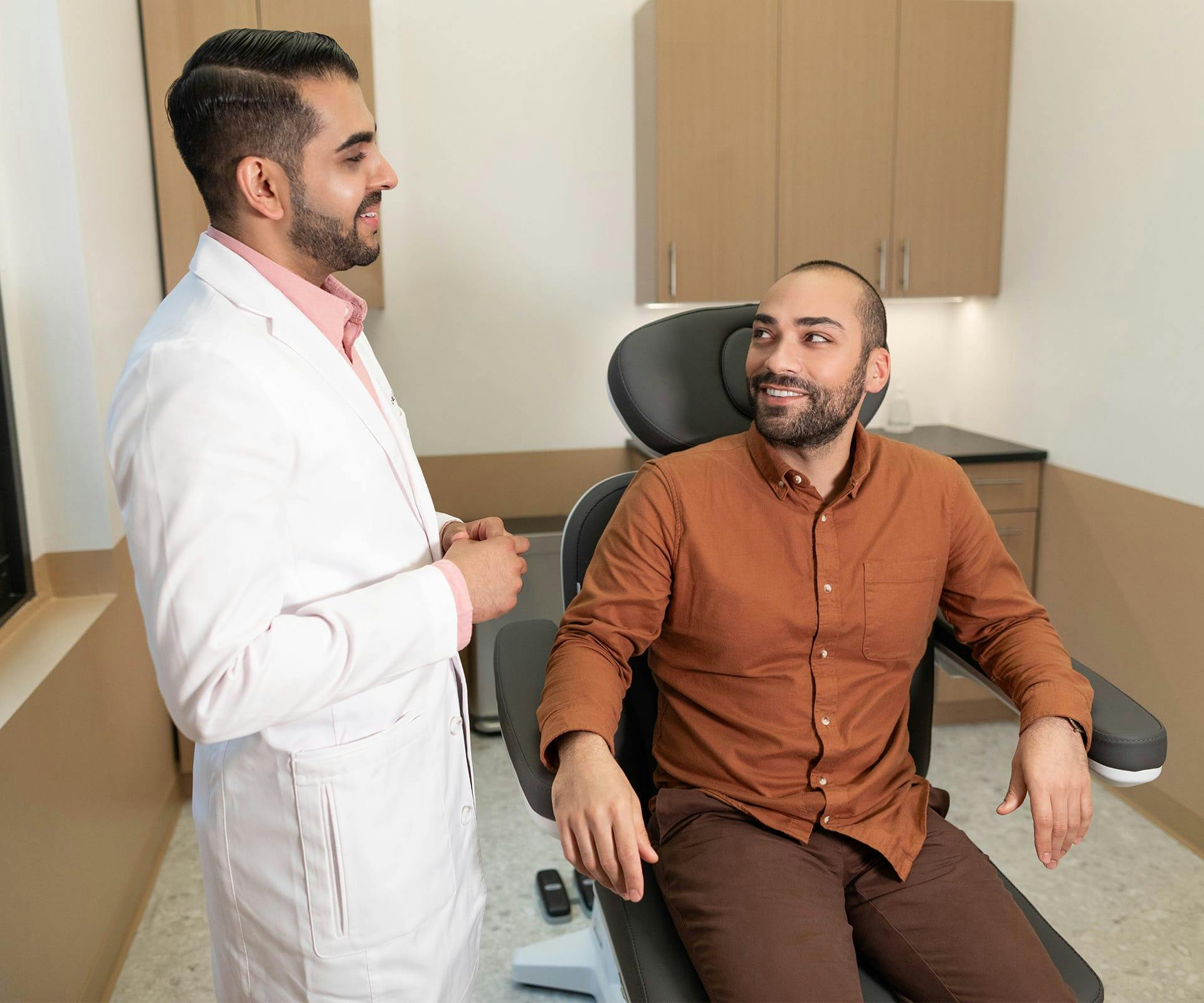 man in examination chair with doctor standing next to him