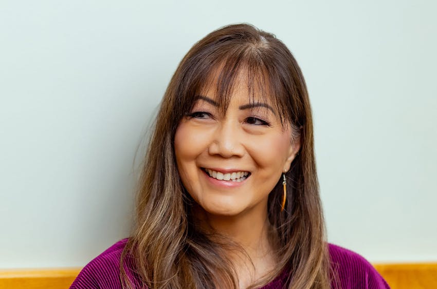 woman smiling with bangs and purple shirt