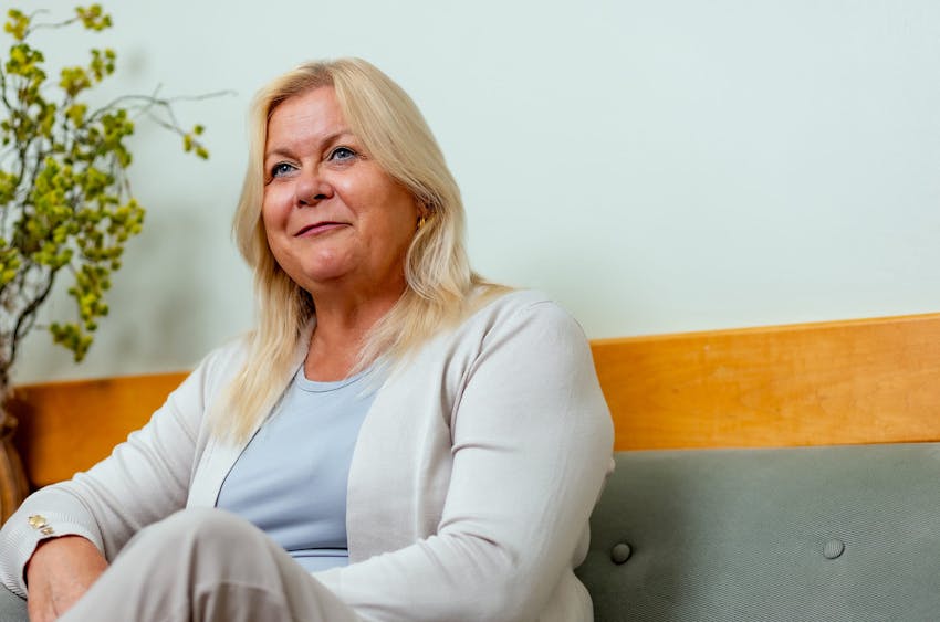 woman with white jacket sitting on couch