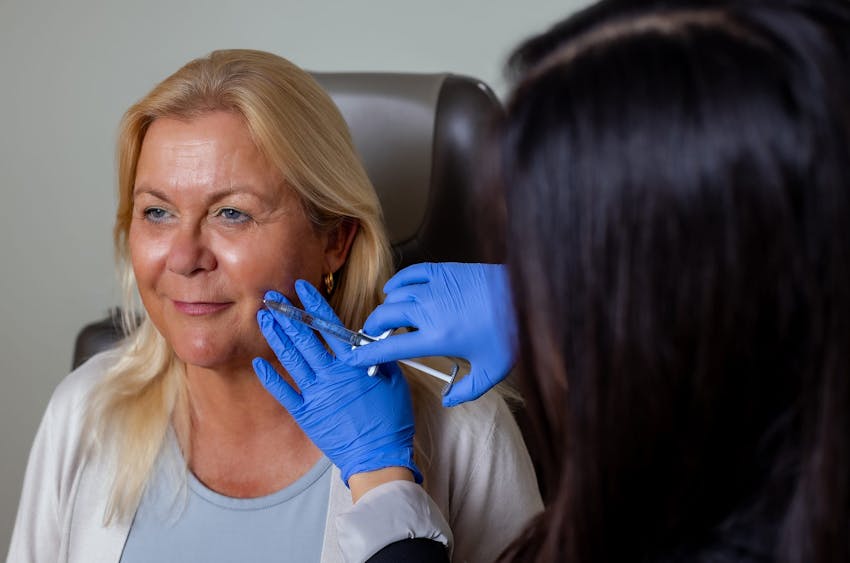 woman getting injection in her dimple area on her cheek
