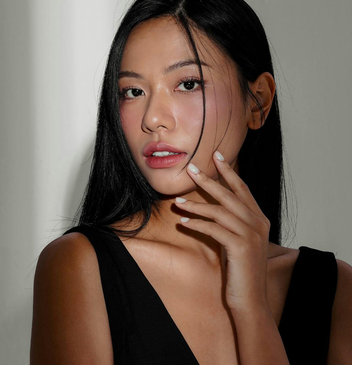 woman looking forward with her hand on her jaw