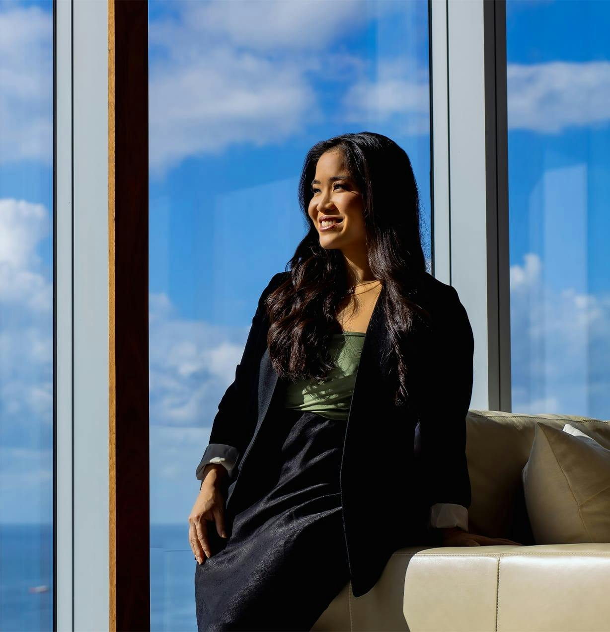 woman standing next to window looking out of it